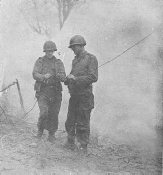 Repairing a broken field wire under cover of a smoke screen.